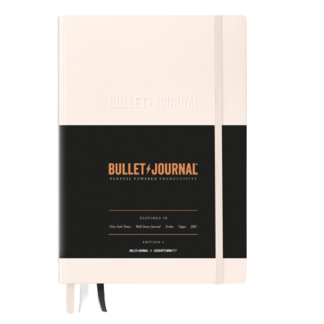 Bullet Journal notebook with beige cover and black band on a white background