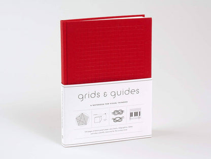 Red notebook with 'grids & guides' packaging on a white background