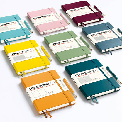 Collection of colorful Leuchtturm1917 notebooks on a white background