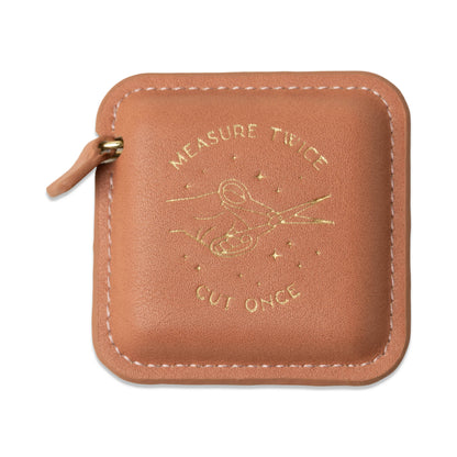 Brown leather pouch with engraved text and airplane design on a white background