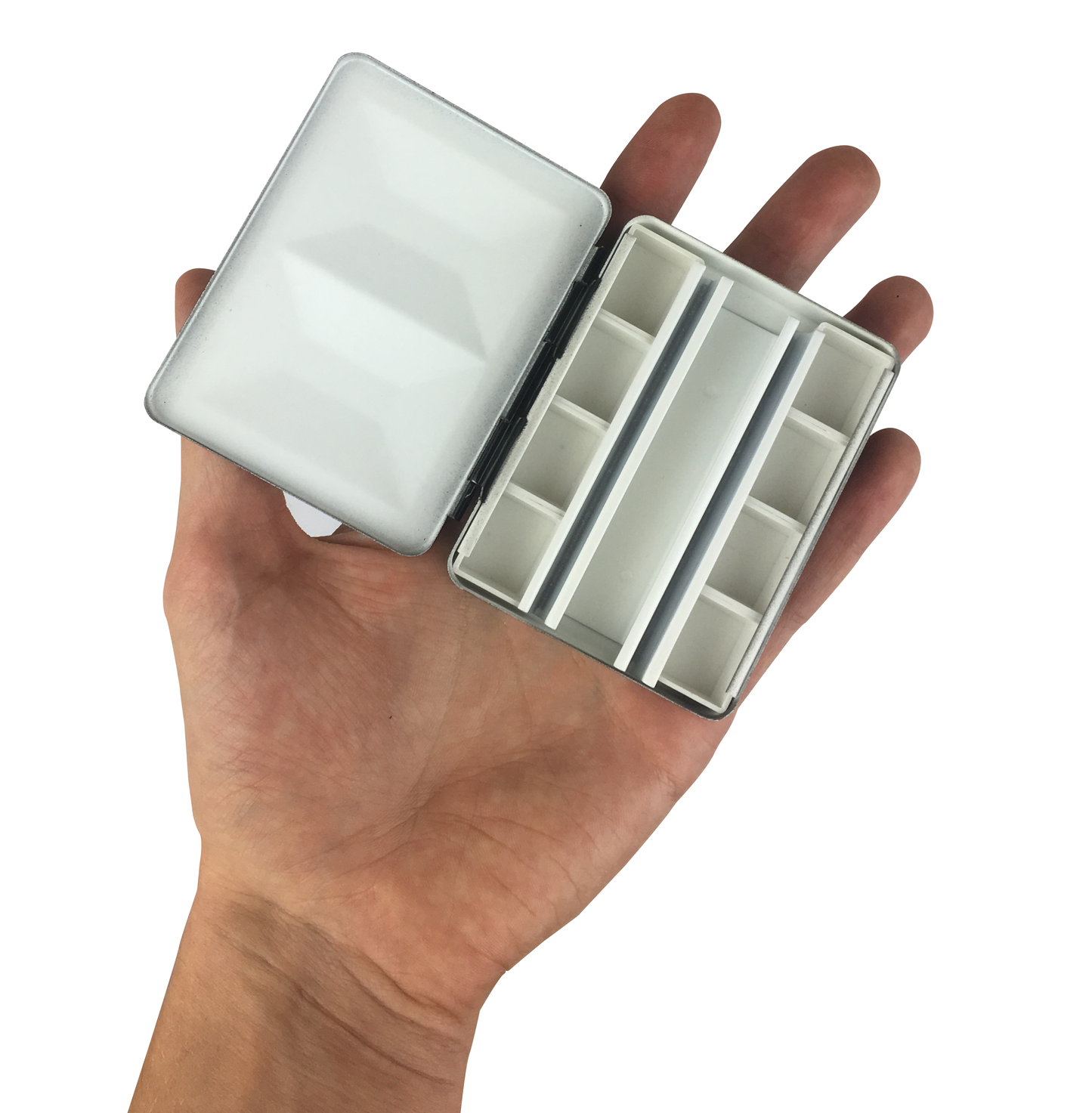 Hand holding a small, open metallic case with compartments on a white background