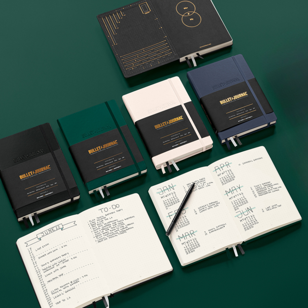 Collection of Bullet Journal notebooks on a green background