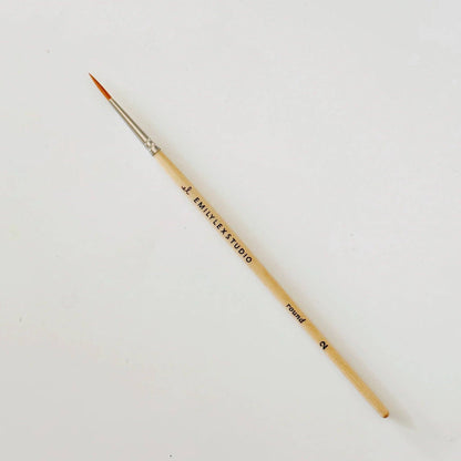 Paintbrush with wooden handle and metal ferrule on a white background