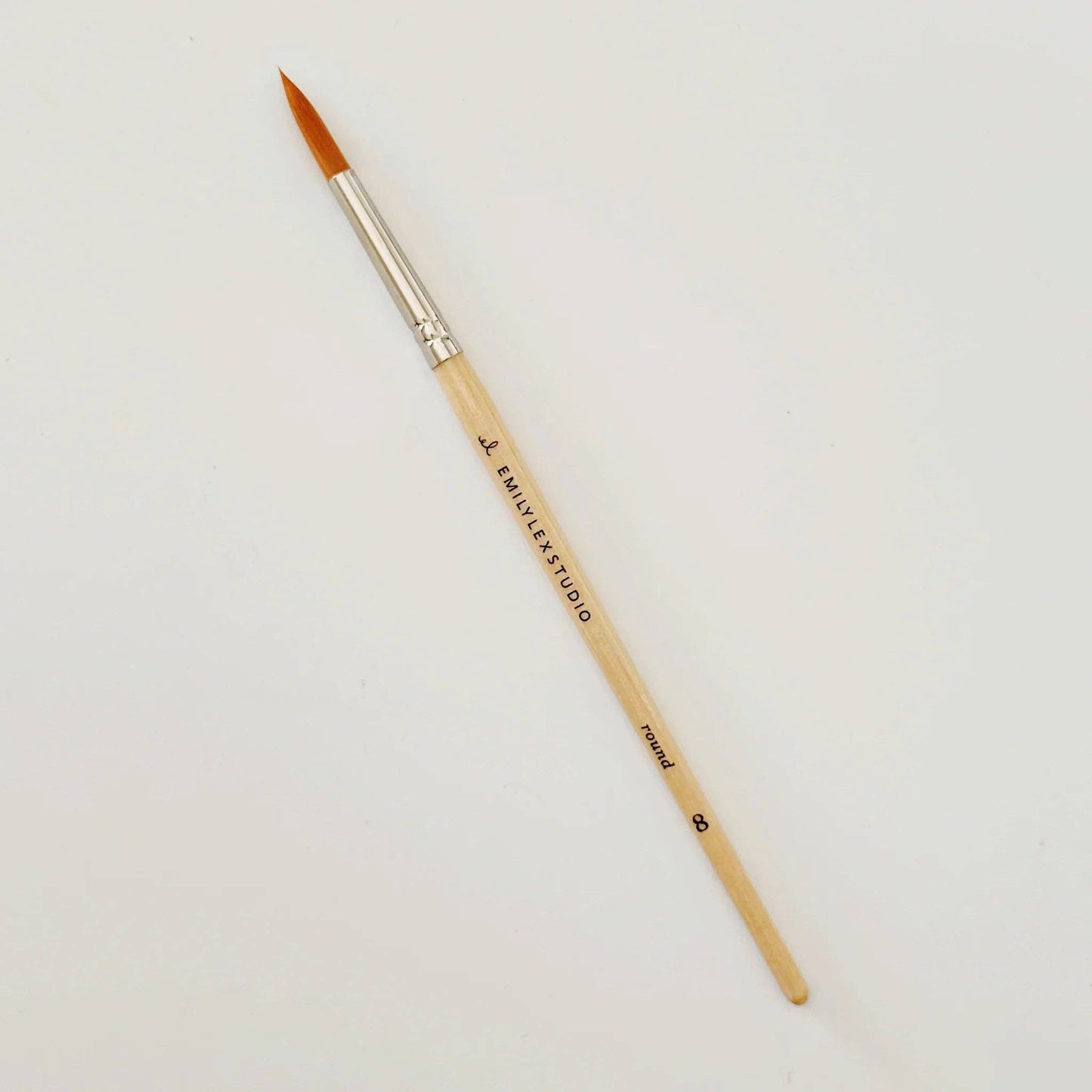 Paintbrush with wooden handle and silver ferrule on a light gray background