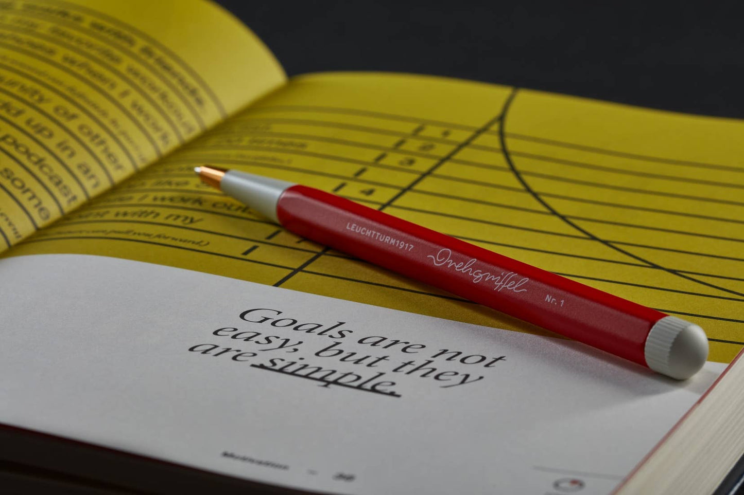 Red pen on a yellow book with a motivational quote