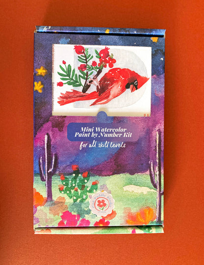 Mini watercolor paint by number kit with a colorful design on an orange background