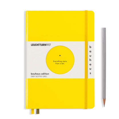 Yellow notebook with Bauhaus edition label and a pencil on a white background