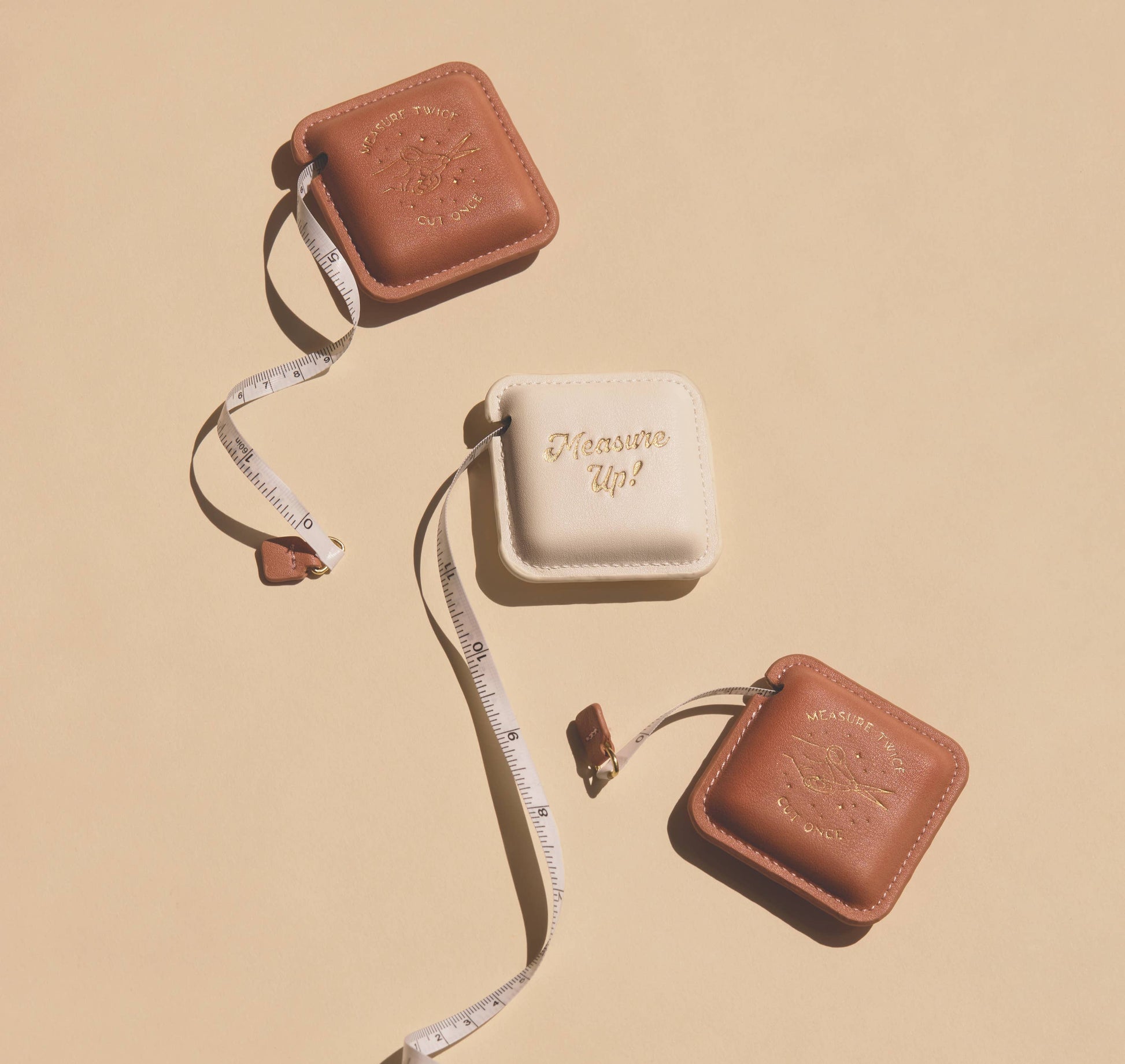 Brown and beige measuring tape with 'Measure Up!' text on a beige background