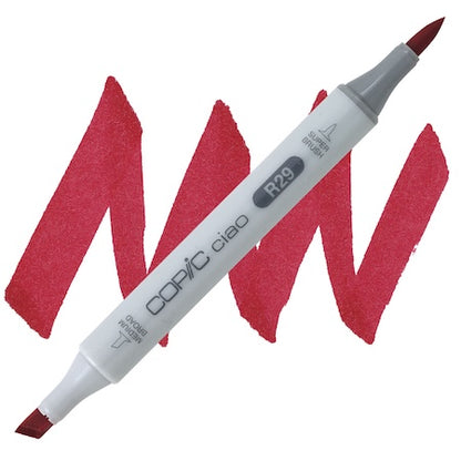 A double-ended Copic Ciao marker with a brush tip on one end and a medium broad tip on the other, with red lipstick applied to the marker.