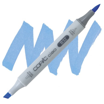 A Copic Ciao marker in pale blue color with a super brush tip and a medium broad tip combo, displayed on a blue background.