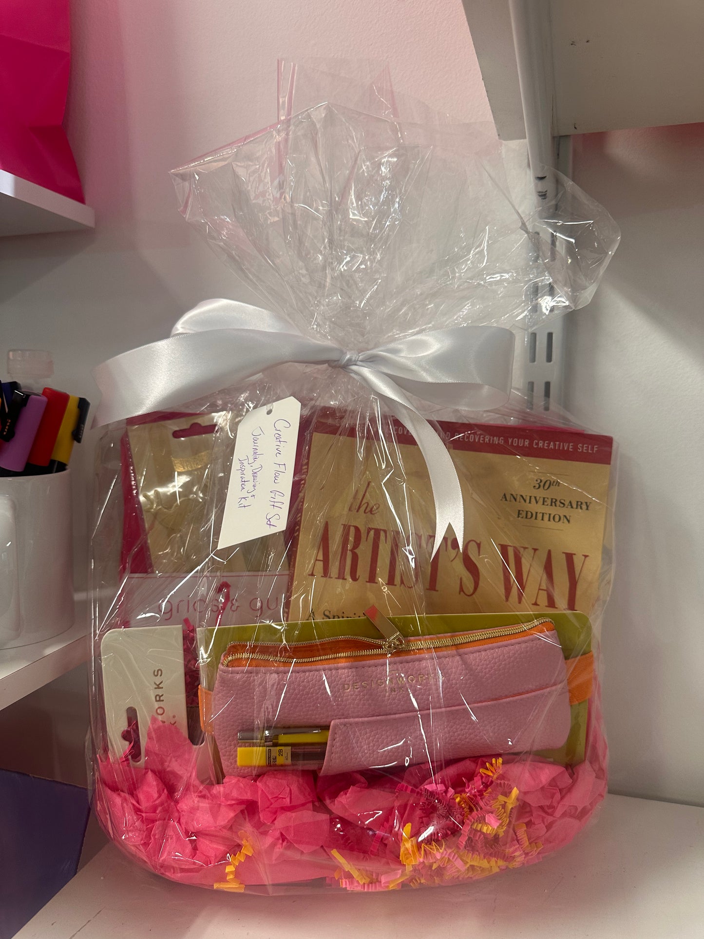 Gift basket with 'The Artist's Way' book and other items, tied with a white ribbon.