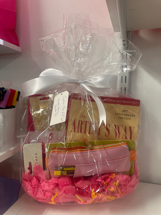 Gift basket with 'The Artist's Way' book and other items, tied with a white ribbon.