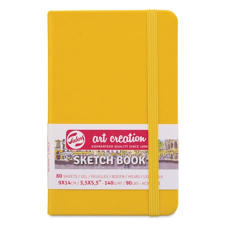 Yellow sketchbook with Tobin art creation branding on a white background