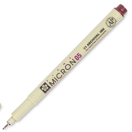 A close-up of the Sakura Pigma Micron Pen, showing the .45mm tip and the burgundy colored cap.