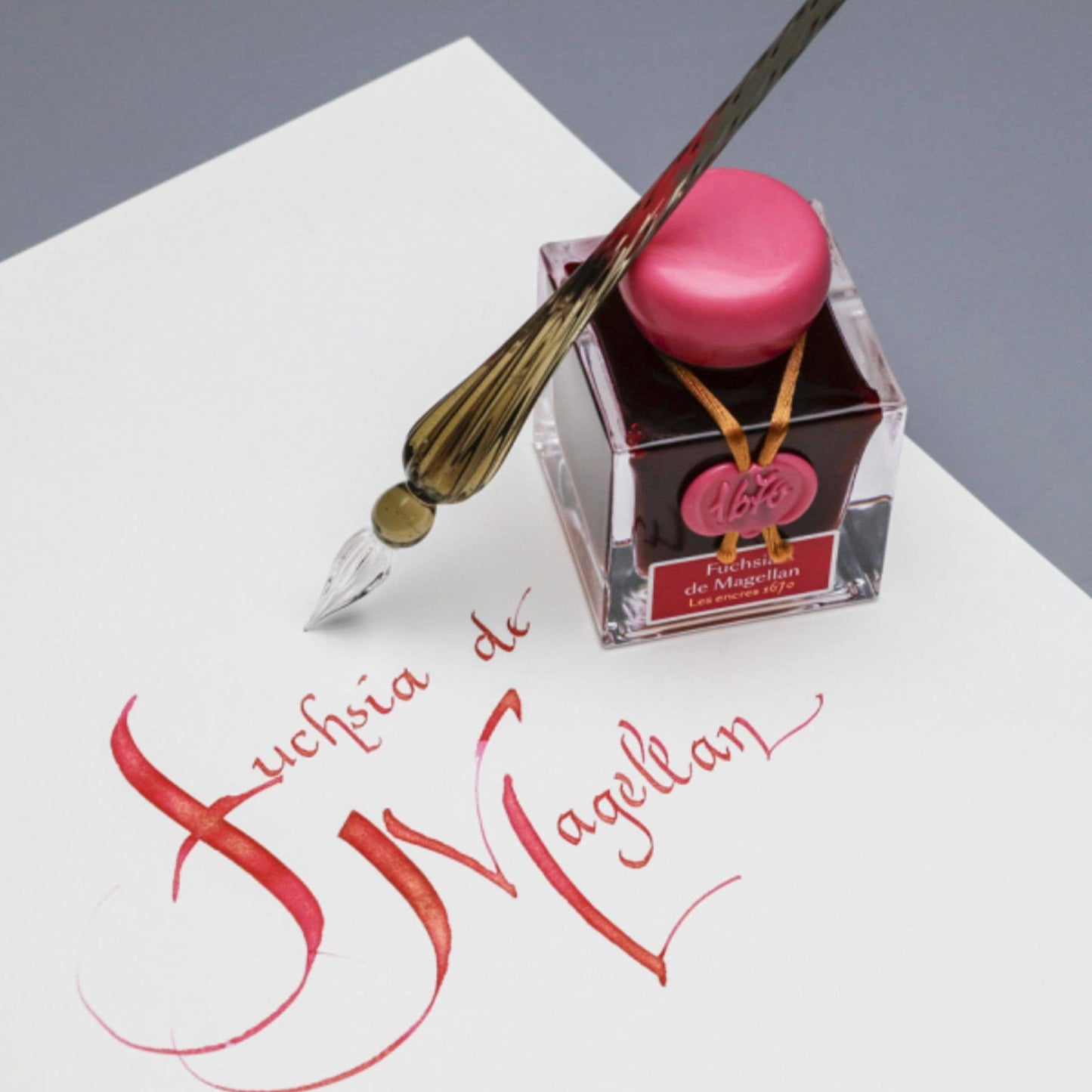 Ink bottle with a fountain pen and calligraphy on a white surface