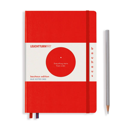Red notebook with white cover featuring Leuchtturm1917 branding and a pencil on a white background