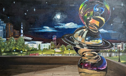 Colorful sculpture with a cityscape background at night